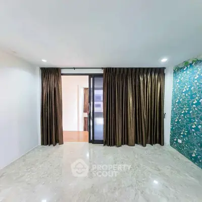 Spacious living room with elegant curtains and marble flooring, perfect for modern living.