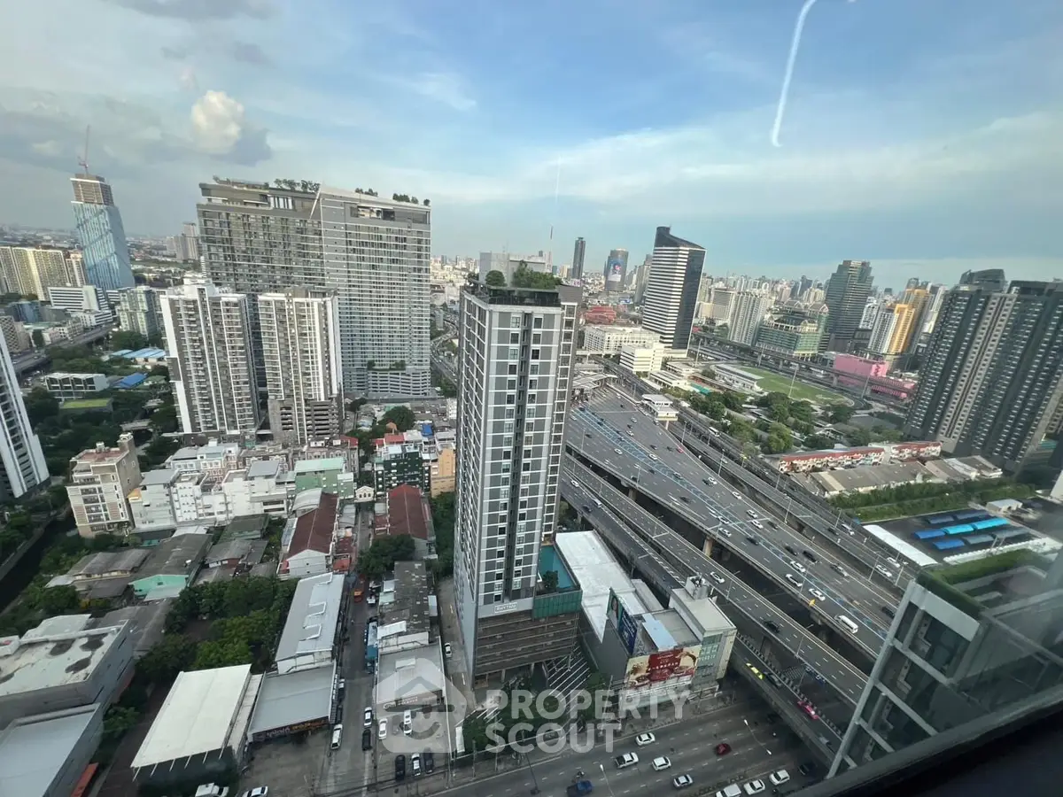 Stunning cityscape view from a high-rise building showcasing urban skyline and bustling highways.