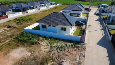 Charming suburban house with modern roof design and spacious yard in a peaceful neighborhood.