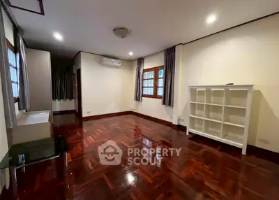 Spacious living room with polished wooden floors and ample natural light.