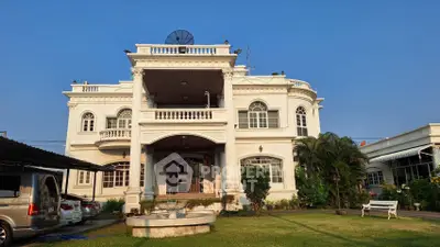 Stunning colonial-style mansion with lush garden and elegant facade, perfect for luxury living.