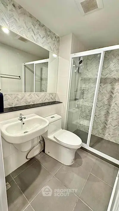 Modern bathroom with glass shower enclosure and stylish tile design