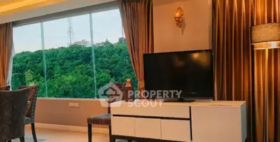 Luxurious living room with stunning forest view through large windows, elegant decor, and modern furnishings.