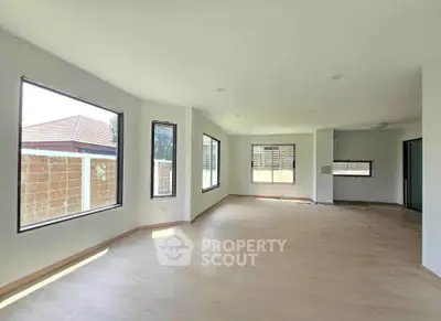 Spacious empty living room with large windows and natural light