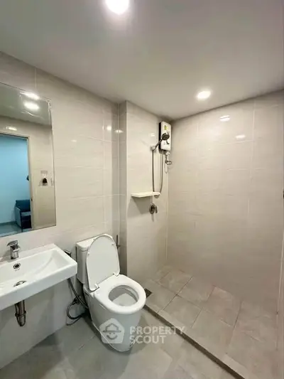 Modern bathroom with sleek fixtures and walk-in shower in a contemporary apartment.