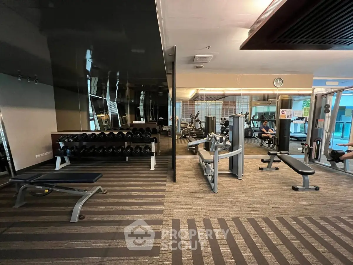 Spacious modern gym with state-of-the-art equipment and sleek design, perfect for fitness enthusiasts.