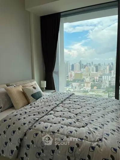 Luxurious bedroom with stunning city view and elegant decor in high-rise apartment.