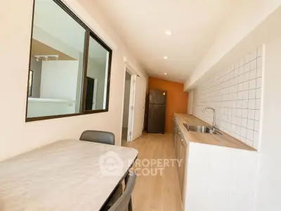 Modern kitchen with sleek countertops and dining area in a bright, open layout apartment.