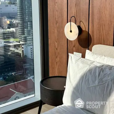 Modern bedroom with city view and stylish wall lamp