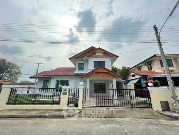 Charming two-story house with red roof and spacious driveway in a serene neighborhood.