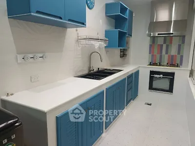 Modern kitchen with blue cabinets, gas stove, and sleek design