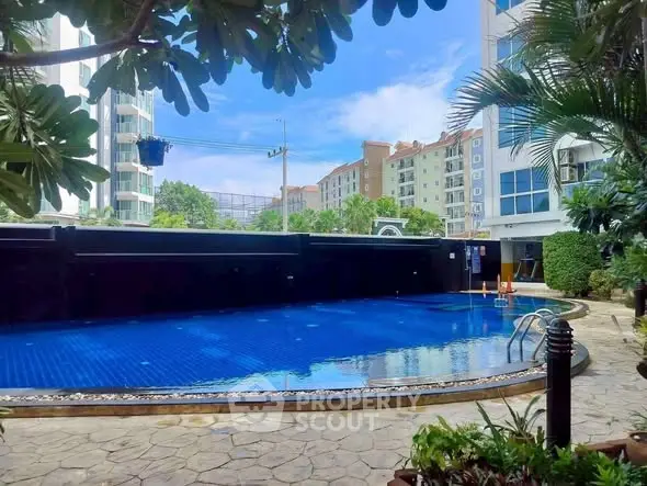 Luxurious residential pool area with lush greenery and modern architecture.