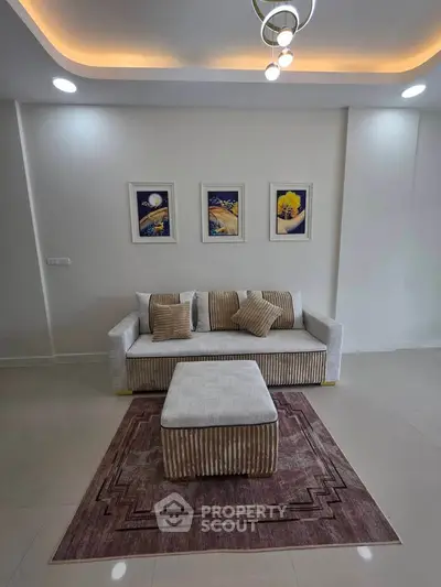 Modern living room with stylish sofa, elegant lighting, and contemporary artwork.