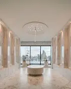 Luxurious marble bathroom with stunning city view and elegant chandelier.