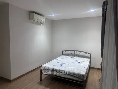 Minimalist bedroom with air conditioning and natural light