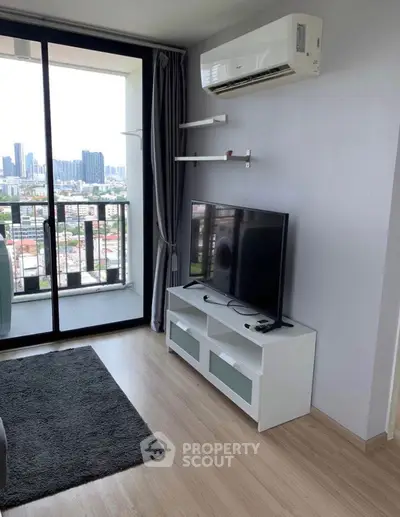 Modern living room with city view, featuring sleek TV setup and air conditioning.