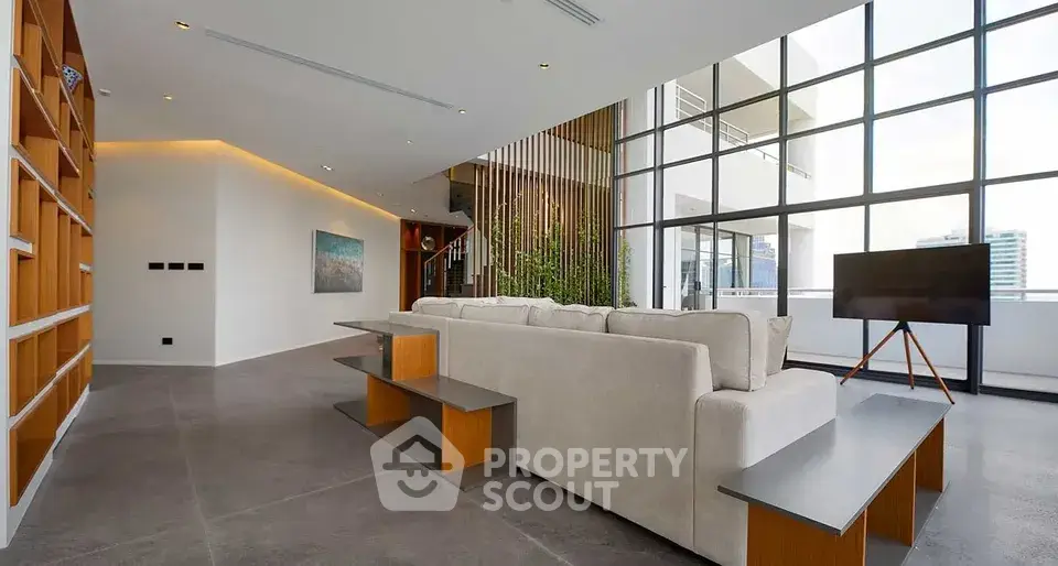 Spacious modern living room with floor-to-ceiling windows and stylish decor