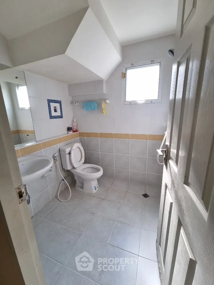 Modern bathroom with white tiles and natural light