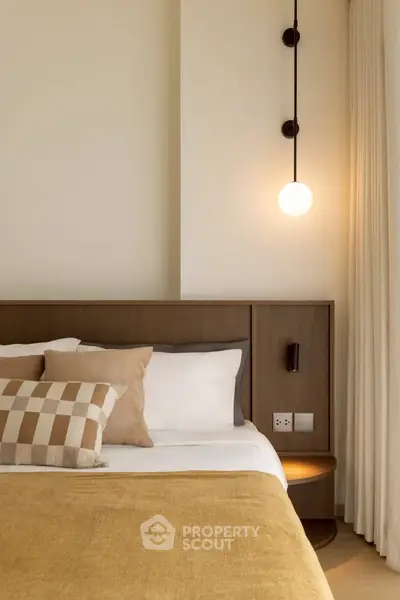 Modern bedroom with stylish lighting and cozy bedding in a contemporary home.