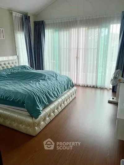Spacious bedroom with elegant decor and large windows for natural light.