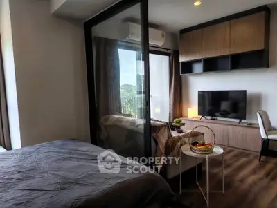 Modern bedroom with glass partition and cozy living area