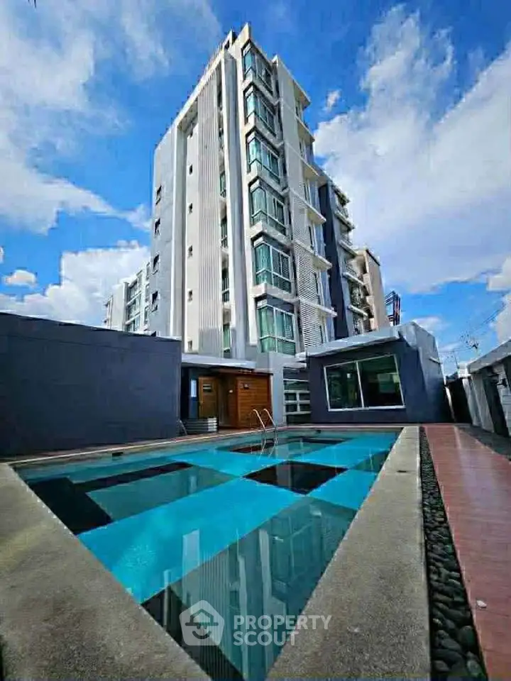 Modern apartment building with pool and clear blue sky