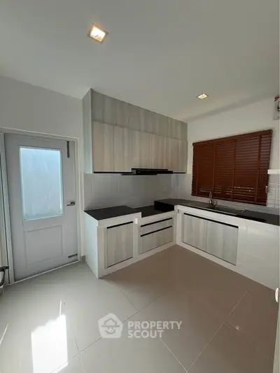 Modern kitchen with sleek cabinetry and large window for natural light