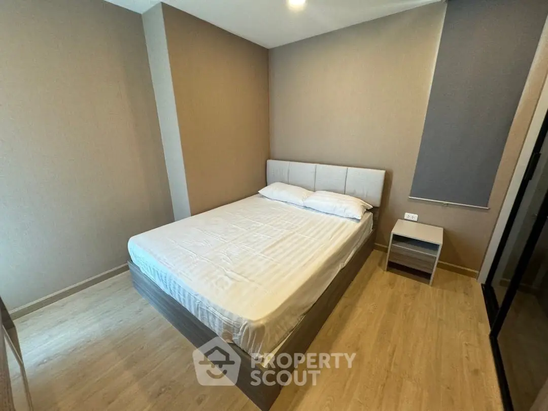 Modern bedroom with minimalist design and cozy ambiance, featuring a comfortable bed and sleek wooden flooring.