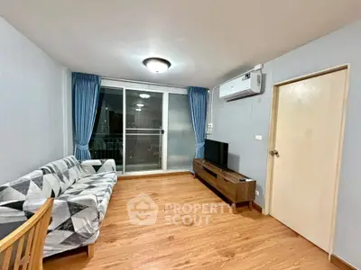 Spacious living room with modern decor and large window for natural light.