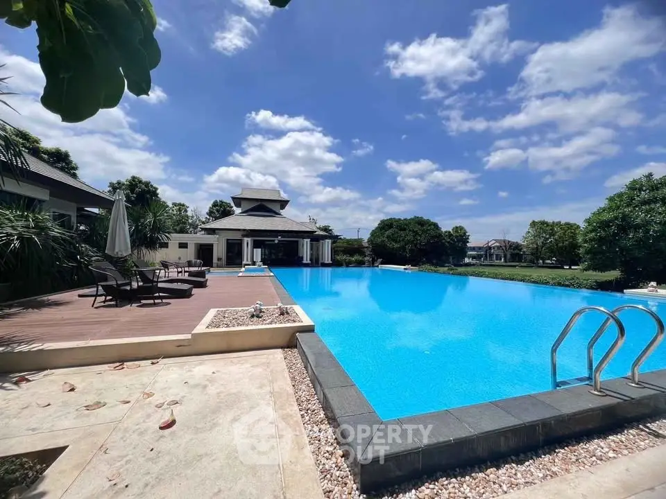Luxurious outdoor pool area with clear blue water and elegant deck seating, perfect for relaxation.