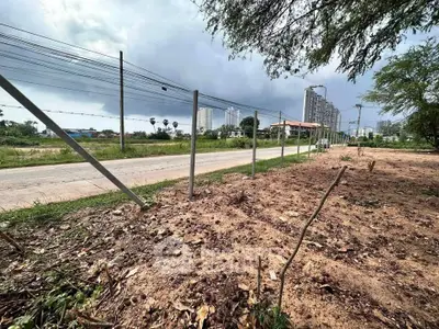 Vacant land plot with road access and city skyline view, ideal for development opportunities.