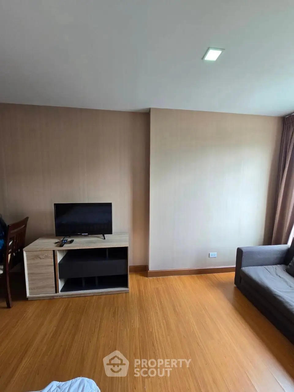 Modern living room with wooden flooring and sleek furniture in a cozy apartment.