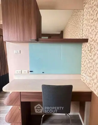 Modern study area with stylish desk and chair, featuring elegant wallpaper and ample storage space.