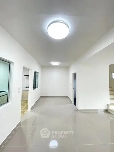 Spacious modern interior with sleek tile flooring and bright lighting, ideal for versatile living space.