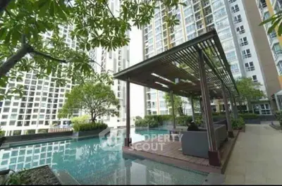 Luxurious condominium pool area with modern seating and lush greenery