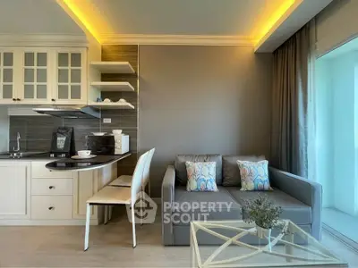 Modern living room with open kitchen, stylish decor, and cozy seating area in a contemporary apartment.