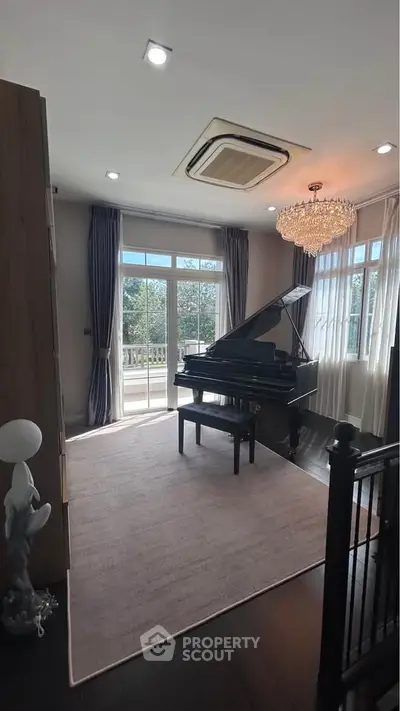 Elegant living room with grand piano and chandelier, featuring large windows and balcony access.