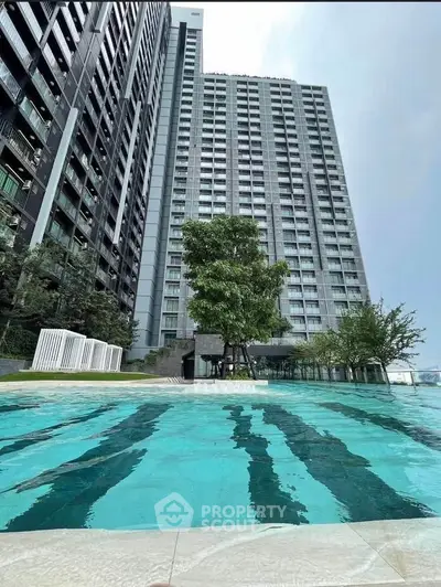 Modern high-rise building with a luxurious swimming pool and lush greenery, perfect for urban living.