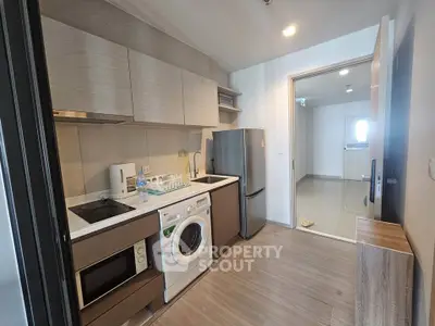 Modern kitchen with washing machine and sleek appliances in stylish apartment