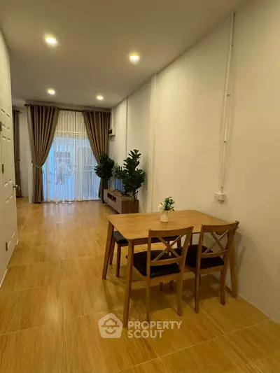 Spacious living room with wooden flooring and elegant dining area, perfect for modern living.