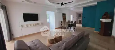 Spacious modern living room with stylish decor and open dining area, perfect for entertaining.