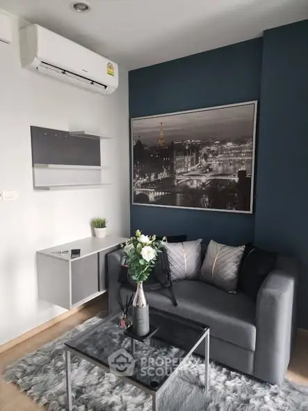 Modern living room with stylish decor and air conditioning, featuring a cozy sofa and elegant wall art.