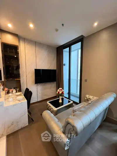 Luxurious living room with elegant sofa and modern decor, featuring a sleek TV and stylish dining area.