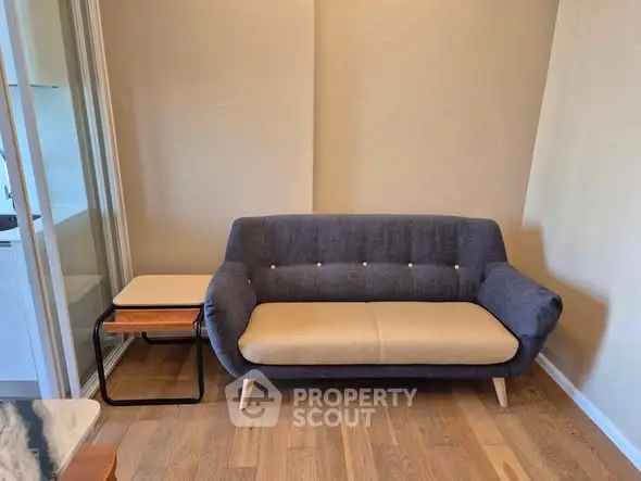 Cozy living room with modern sofa and wooden flooring, perfect for relaxation.