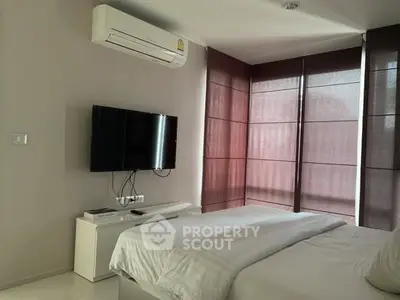 Modern bedroom with air conditioning and wall-mounted TV, featuring stylish window blinds.