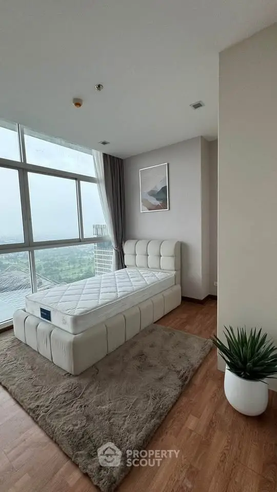 Modern bedroom with large windows and scenic view, featuring a stylish bed and cozy decor.