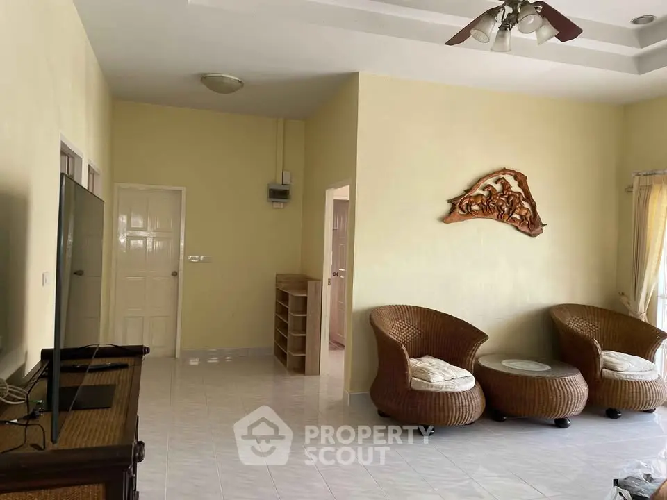 Spacious living room with wicker furniture and wall art, perfect for relaxation.