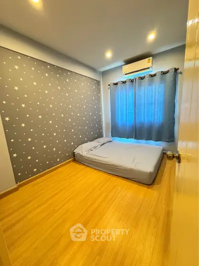 Cozy bedroom with starry wallpaper and wooden flooring