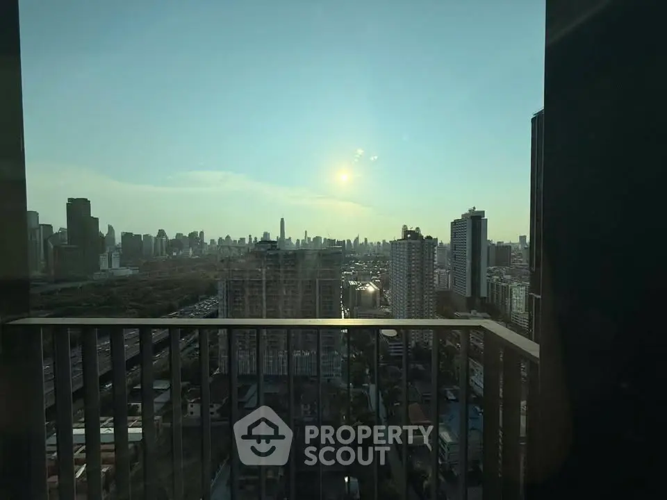Stunning cityscape view from high-rise balcony at sunset, perfect for urban living enthusiasts.