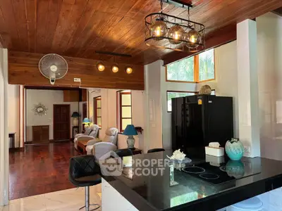 Spacious open-layout kitchen with modern lighting and cozy living area